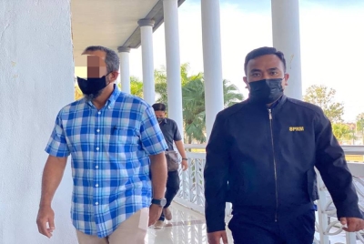 Tertuduh (kiri) tiba di Mahkamah Sesyen pada Rabu.