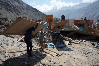 Orang ramai berjalan kaki di kawasan bencana yang mengalami kerosakan akibat tanah runtuh di Secocha, Arequipa, Peru. - Foto EPA