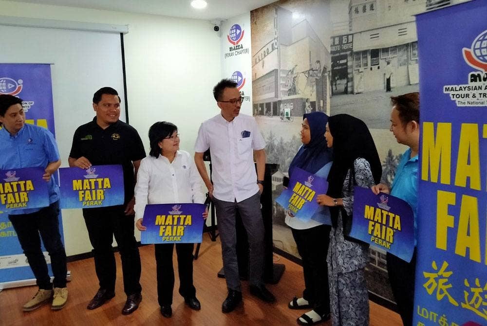 Yu Ken (tengah) ketika mempromosikan MATTA Fair Perak di Pejabat MATTA Cawangan Perak di sini pada Jumaat.