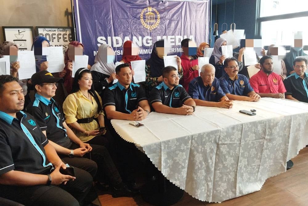 Hishamuddin (duduk lima kiri) bersama beberapa mangsa membuat sidang akhbar mengenai penipuan pelaburan skim kutu di sini pada Jumaat.