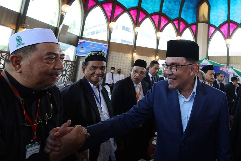 Anwar bersalaman dengan pemimpin-pemimpin Islam Thailand selepas menunaikan solat Jumaat di Pusat Islam Thailand pada Jumaat. - Foto Bernama
