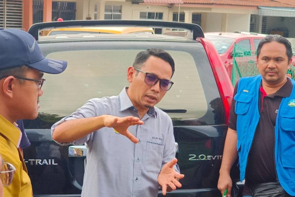 Mohd Azlan (tengah) meninjau keadaan cerun runtuh di Taman Chenderong Jaya, Batu Gajah pada Jumaat.