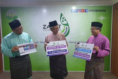Ahmad Zakiyuddin (tengah) bersama Amran (kiri) dan Samsudin (kanan) menunjukkan kad laporan prestasi kutipan serta agihan zakat pada 2022.