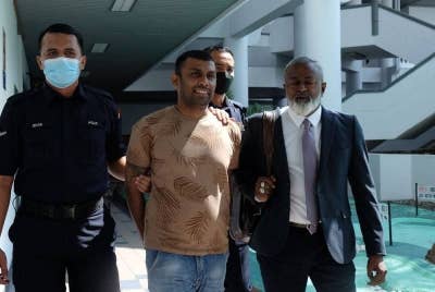 Tamil Kumaran ketika dibawa keluar dari Mahkamah Sesyen di sini, pada Jumaat.