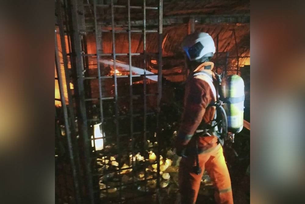 Anggota menjalankan pemadaman melibatkan enam kedai separa kekal di Taman Malinja, Kampung Gajah. - Foto ihsan bomba