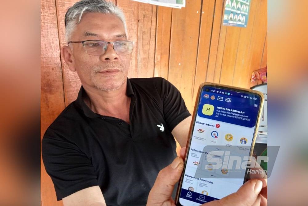 Husni menunjukkan MyJPJ yang berjaya dimuat naik di telefon bimbitnya.