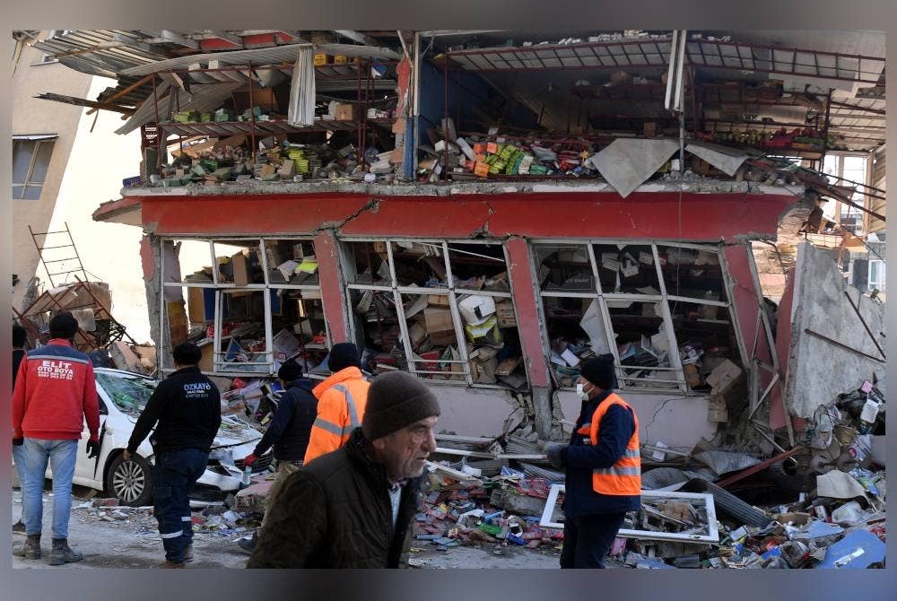 Orang ramai berjalan melepasi bangunan yang rosak di Antakya, wilayah Hatay, Turkiye. - Foto Xinhua