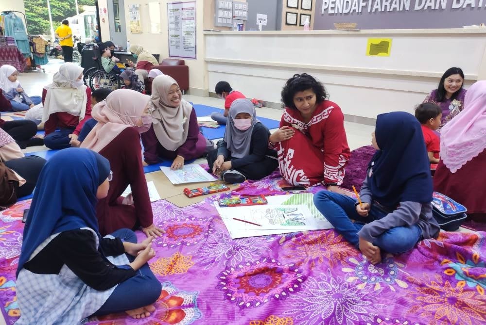 Dr Amara (baju merah) berkata sesuatu kepada pesakit Spina Bifida yang hadir pada Program Hari Kesedaran SiBIAM dengan kerjasama Jabatan Perubatan Rehabilitasi & Jabatan Pediatrik Hospital Sultanah Nur Zahirah (HSNZ) di sini pada Sabtu.