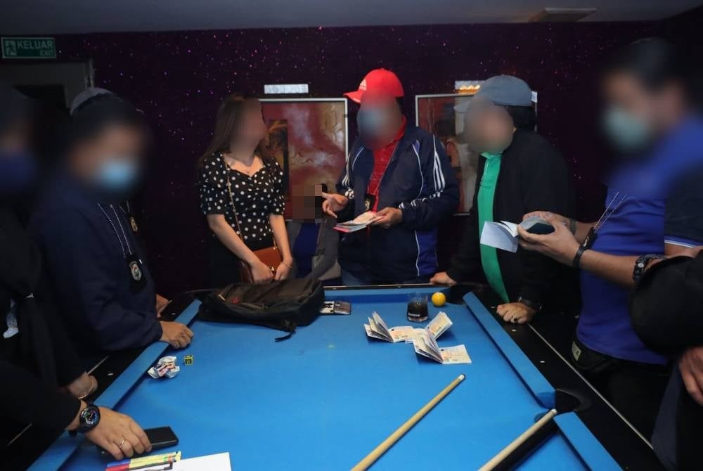 Anggota imigresen menjalankan pemeriksaan terhadap wanita warga asing dalam serbuan di pusat hiburan dan rumah transit sekitar Kuala Lumpur dan Selangor, pada Khamis.