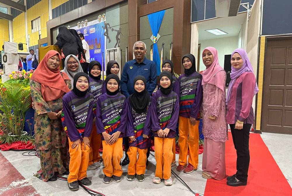 Khairudin (tengah) bergambar bersama murid-murid Sekolah Kebangsaan Seberang Perak pada Majlis Anugerah Sukan Sekolah Perak di Seri Iskandar pada Sabtu.