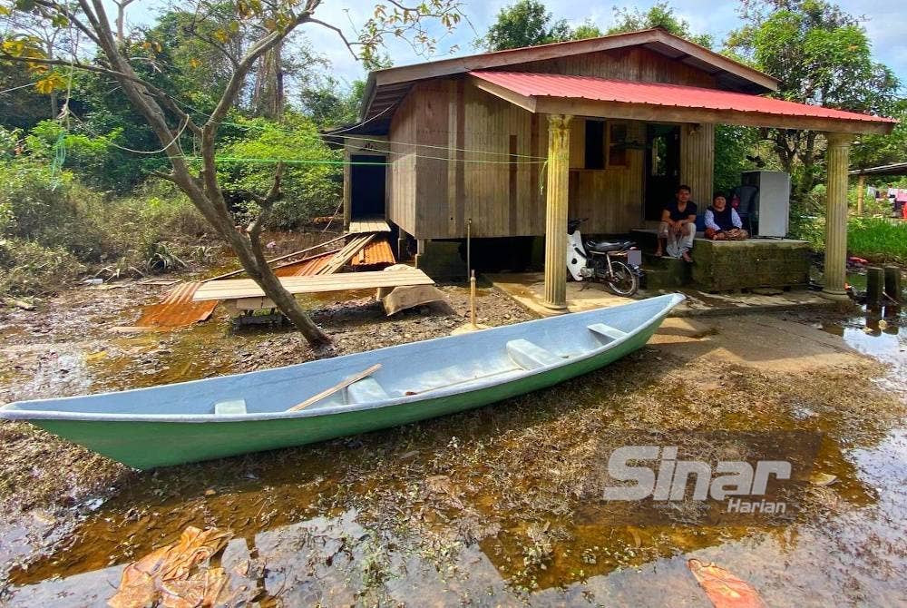 Mek Yam dan Yusof di hadapan rumah mereka di Kampung Bendang Perol, Rantau Panjang yang semakin uzur disebabkan terlalu lama ditenggelami air disebabkan banjir termenung.