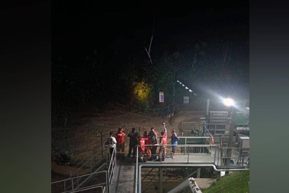 Anggota bomba sedang mencari dan menyelamat mangsa yang dipercayai dihanyutkan arus deras di Sungai Pisang pada Ahad.