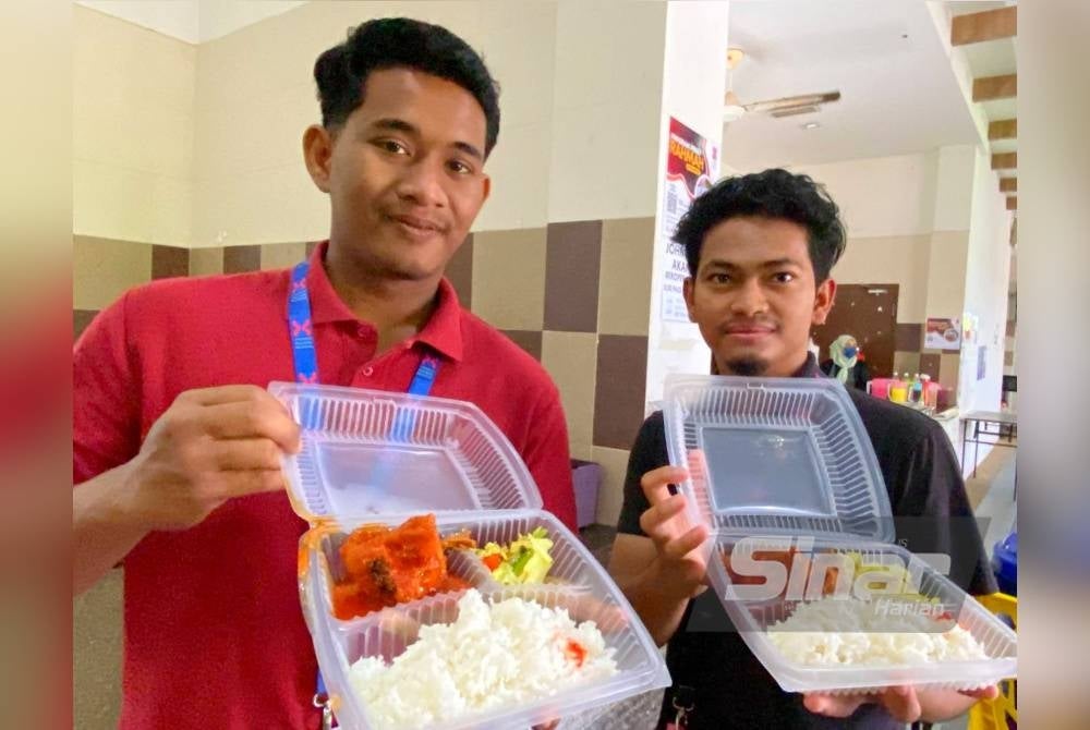 Muhammad Adam (kiri) dan Mohd Izham menunjukkan Menu Rahmah yang dibeli mereka di Kafeteria UMK Bachok pada Isnin.