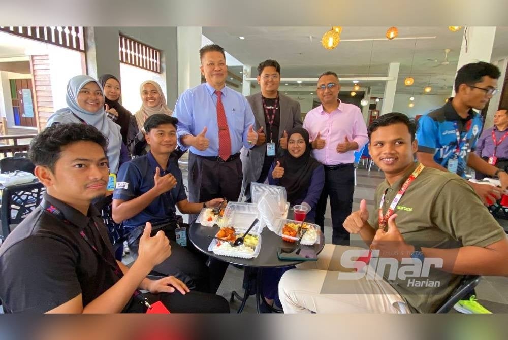 Razli (berdiri, empat dari kiri) meninjau suasana makan tengah hari di Kafeteria UMK Bachok sempena hari pertama pengenalan Menu Rahmah pada Isnin.