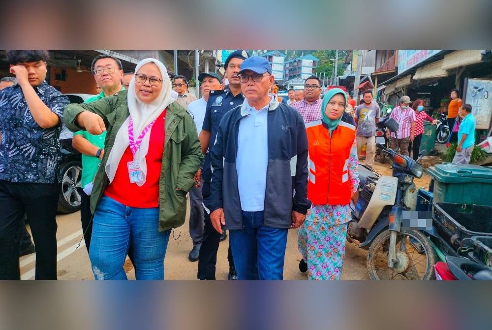 Wan Rosdy (kanan) ketika melawat lokasi banjir lumpur di Kampung Bukit Tinggi pada Isnin.