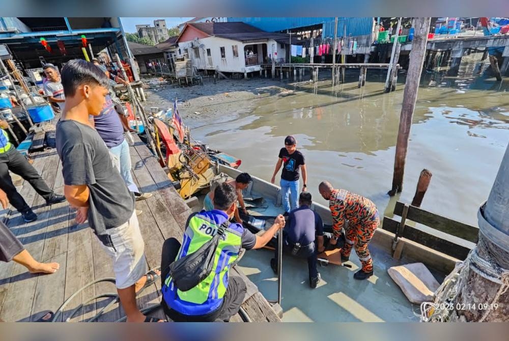 Anggota bomba membantu mengangkat mayat mangsa jatuh laut di Bagan Panchor, Pantai Remis untuk diserahkan kepada pihak polis bagi tindakan lanjut. - Foto ihsan Bomba Perak
