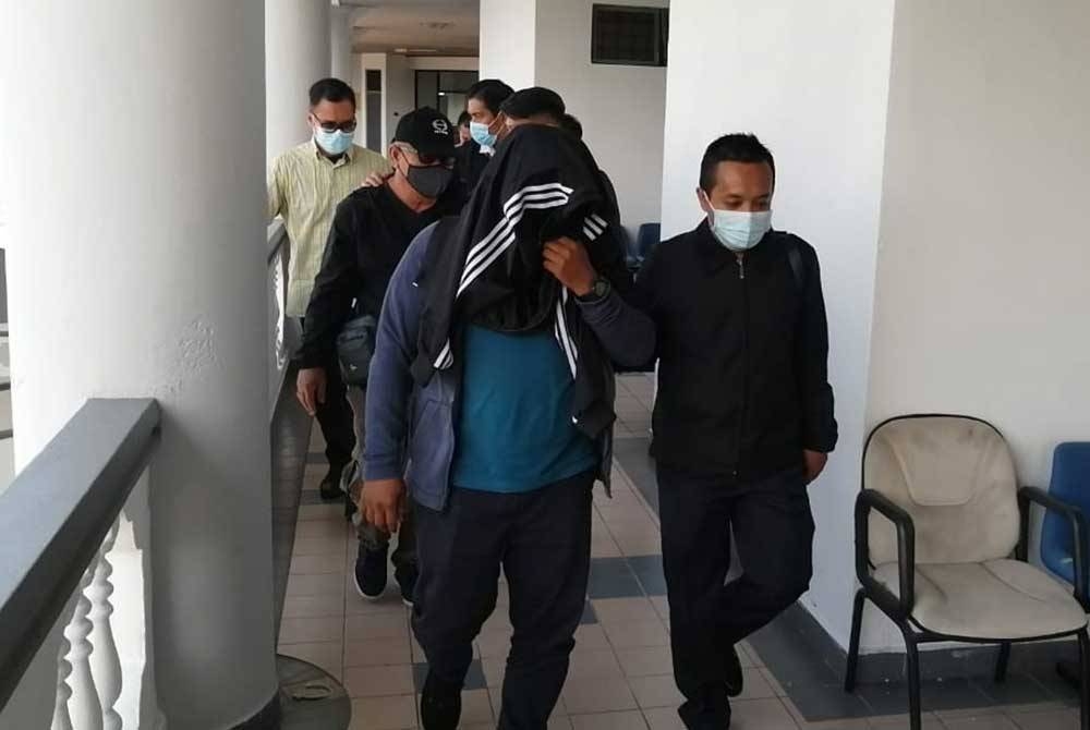 Che Fadzlie Izwan (depan) dan Mohd.Rafi (belakang) ketika dibawa keluar dari Mahkamah Seksyen di sini, pada Selasa.