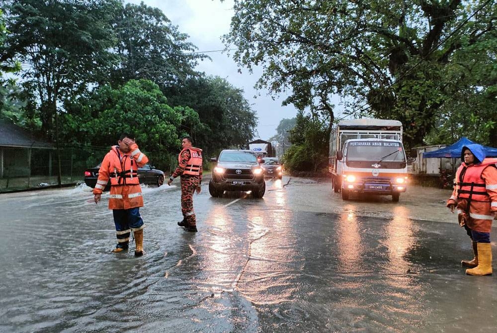 Anggota APM melakukan pemantauan dan kawalan di beberapa kawasan banjir kilat di Tapah. Foto Ihsan APM