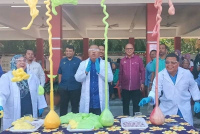 Mohd Zolkafly (tengah) melakukan eksperimen sebagai gimik perasmian Karnival dan Pameran Sains, Teknologi, Kejuruteraan dan Matematik (STEM) di SK Lintang pada Selasa.