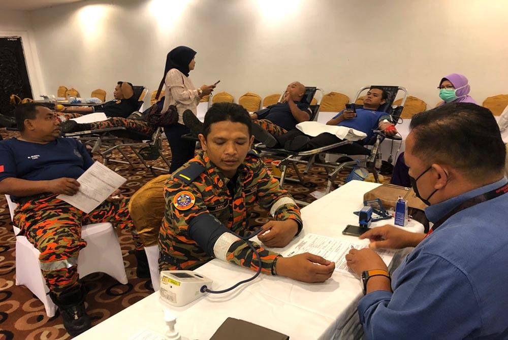 Mohamad Zaki (kiri) melakukan pemeriksaan kesihatan sebelum menderma darah.