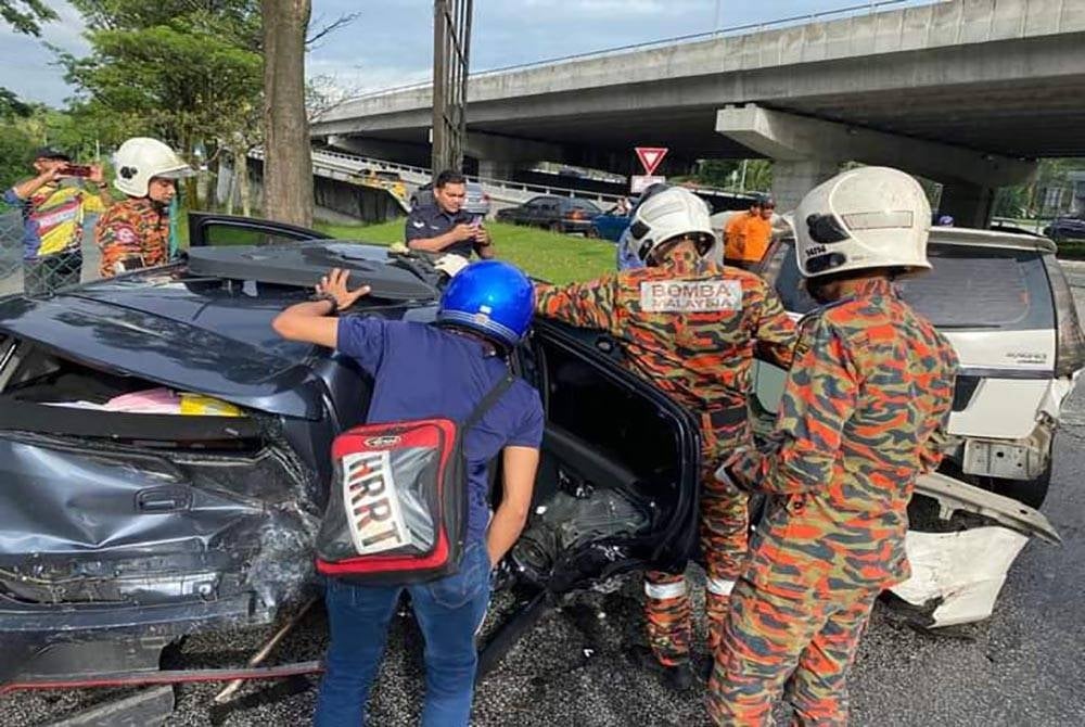Anggota Bomba dan Penyelamat sedang mengeluarkan mangsa yang tersepit dalam kemalangan di Jalan Dato Sulaiman, Taman Tun Dr Ismail, di sini, pada Rabu.