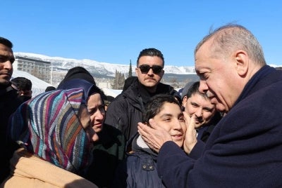 Erdogan (kanan) memberi salam kepada orang ramai ketika melawat kem selepas gempa bumi besar di Kahramanmaras, Turki pada Rabu minggu lepas. - Foto EPA/ Pejabat Akhbar Presiden Turkiye