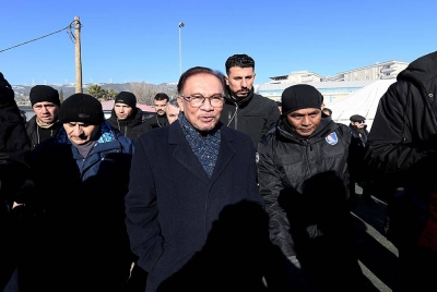 Anwar (tengah) diiringi Ketua Pasukan MAS-10, Abdul Manaf Che Isa (kanan) melihat keadaan bangunan yang runtuh akibat gempa semasa melakukan lawatan di Pusat Operasi SMART di Nurdagi hari ini. - Foto Bernama