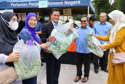 Isa (tiga dari kanan) mengedarkan sayur percuma ketika merasmikan Program NBME Ejen Pemasar FAMA @ Kolej Komuniti Sungai Petani pada Rabu.