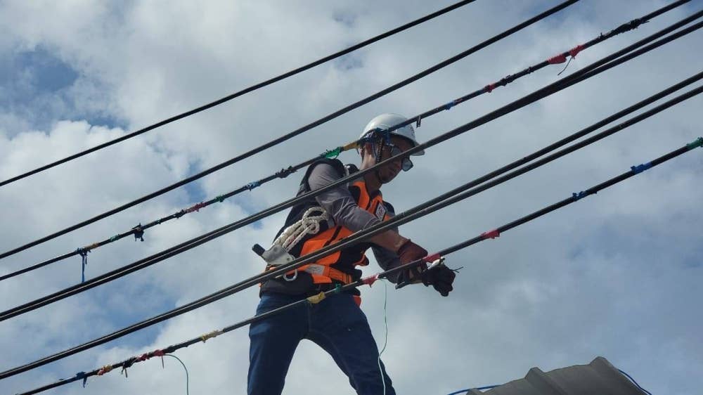 Kerja memotong dawai yang disambungkan ke kabel utama tiang elektrik dilakukan oleh kakitangan SESB dalam operasi bersepadu di Kampung Numbak Kota Kinabalu.