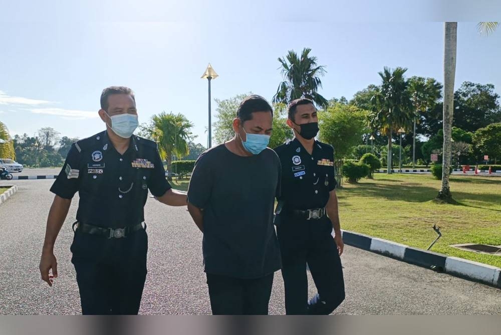 Azahari (tengah) diiringi oleh anggota polis ke Mahkamah Majistret Alor Setar pada Khamis.