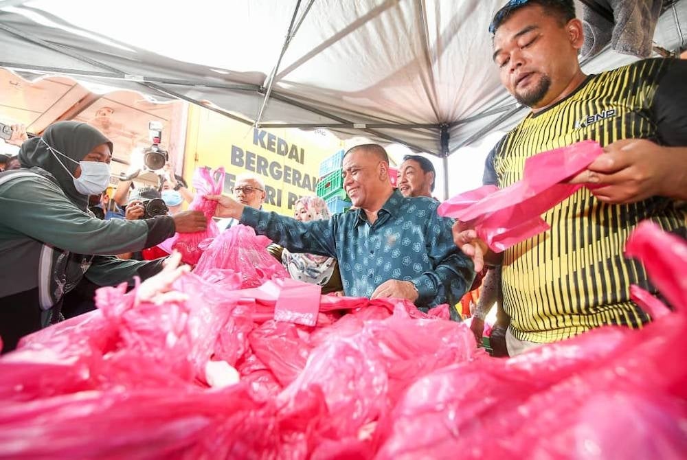 Saarani membantu jualan barangan keperluan ketika meninjau operasi jualan di Pasar Tani Mesra sempena program Mesra Hari Bertemu Pelanggan di Stadium Indera Mulia pada Khamis.
