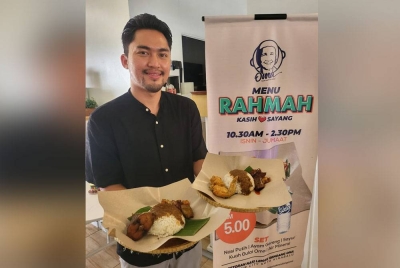 Mohd Effni menunjukkan Menu Rahmah lauk ayam goreng atau ikan goreng berserta sayur dan berkuahkan gulai daging kawah di Restoran Nasi Lemak Oma di Harbour City Kota Kinabalu.