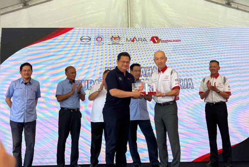 Atsushi Uchiyama (depan, kanan) dan Ketua Pegawai Eksekutif Perbadanan MARA, Datuk Julainie Mohd Salleh bertukar plak pada majlis pelancaran HASO Muadzam Shah pada Khamis.