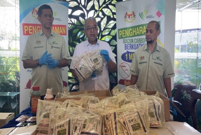 Zahimi (tengah) menunjukkan racun yang dirampas dalam serbuan di Kampung Gajah, Perak.