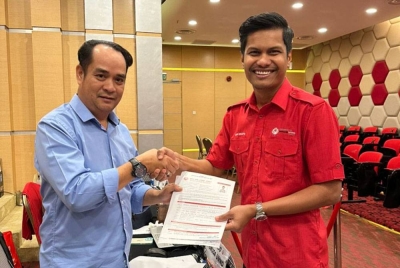 Mohd Shafiq Fhadly (kanan) menyerahkan borang pencalonan jawatan Exco Pemuda UMNO dalam pemilihan UMNO akan datang.