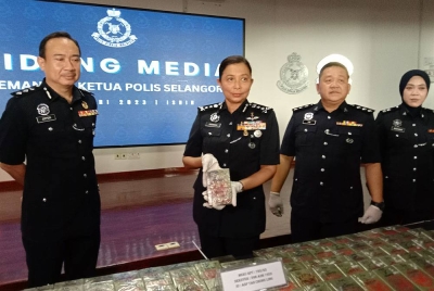 Sasikala Devi (dua dari kiri) menunjukkan antara ketulan dadah jenis heroin base yang dirampas menerusi serbuan pada Rabu.