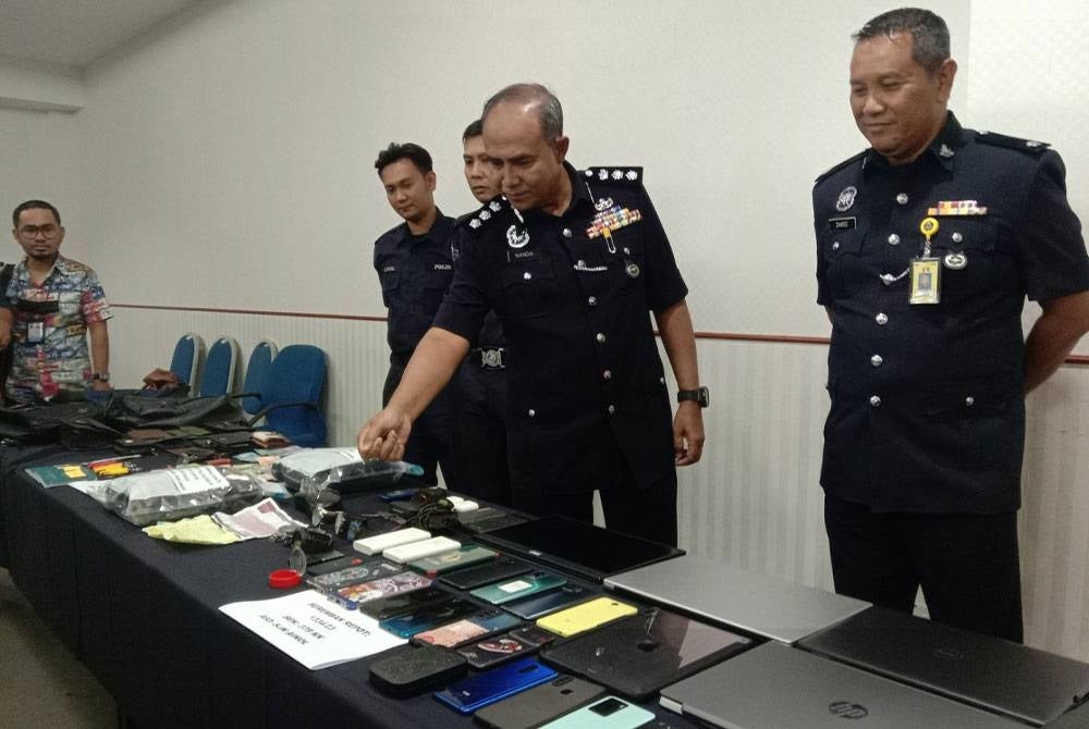 Nanda (dua kanan) menunjukkan barangan yang dirampas daripada suspek.