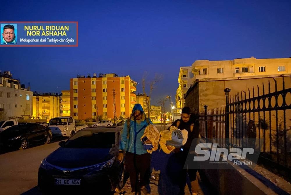 Muaz (kanan) bersama wakil Sinar Harian, Nurul Riduan Nor Ashaha membawa kelengkapan seperti selimut untuk tidur di tempat penempatan sementara di Reyhanli, Turkiye.