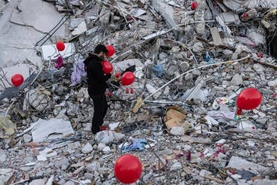 Belon merah diikat pada sisa runtuhan di salah sebuah struktur yang runtuh di Antakya. - Foto: AFP