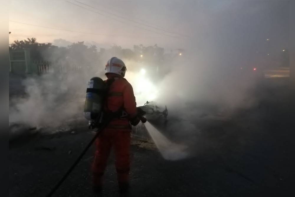 Anggota bomba memadamkan kebakaran berpunca nahas dua motosikal di Jalan Pantai Remis pada Khamis. - Foto Bomba Perak