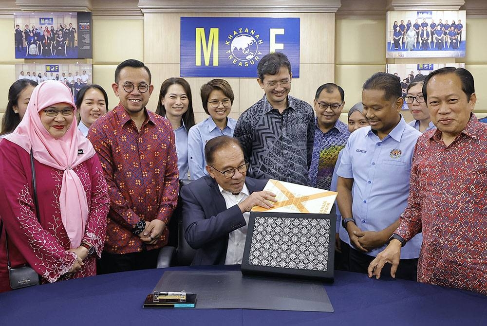 Anwar memasukkan dokumen Belanjawan 2023 ke dalam beg ketika hadir meninjau persiapan penyediaan Belanjawan 2023 bertema Malaysia MADANI di Kementerian Kewangan pada Khamis. - Foto Bernama