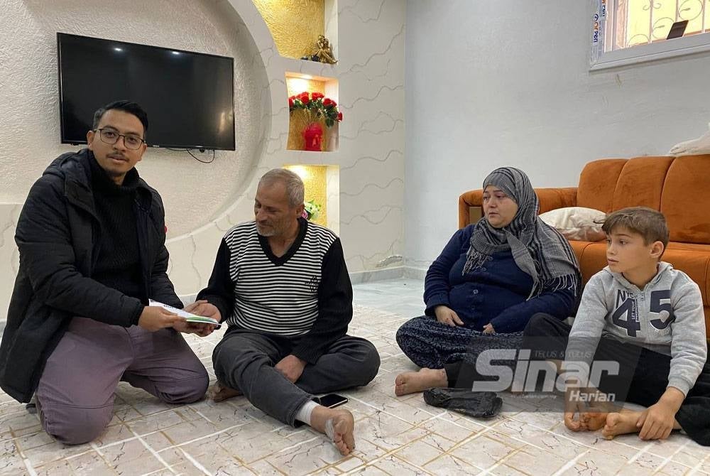 Pengurus Besar Syria Care, Muaz Abd Muein (kiri) menyampaikan bantuan kewangan Tabung #BantuanBencana Sinar Harian x Syria Care kepada keluarga Fevas Tayyar, warga Syria yang menetap di Turkiye.