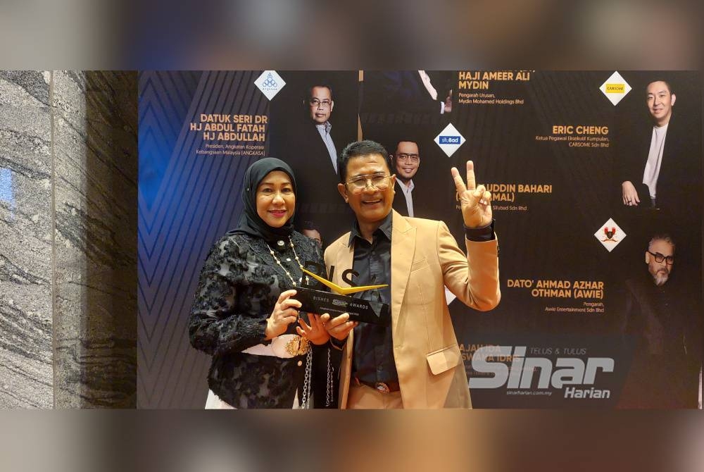 Azmi (kanan) dan isterinya bergambar bersama Anugerah BISA yang diterimanya pada Khamis