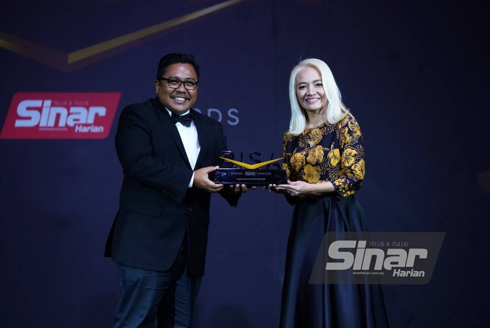 Rasta menerima Anugerah Fesyen Kreatif Batik Pilihan 2023 dari Ketua Pengarang Kumpulan Sinar Harian, Zamri Rambli.