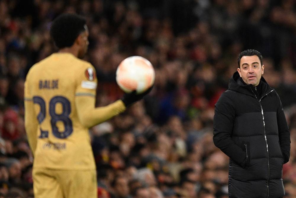 Xavi (kanan) yakin Barcelona akan kembali lebih hebat musim depan. - Foto AFP