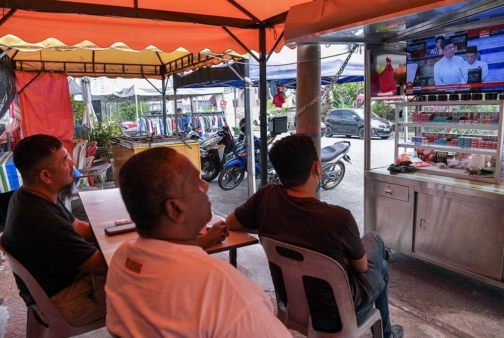 Para peniaga mendengar pembentangan Belanjawan 2023 Malaysia MADANI yang disampaikan oleh Perdana Menteri yang juga Menteri Kewangan Datuk Seri Anwar Ibrahim melalui televisyen pada tinjauan hari ini.