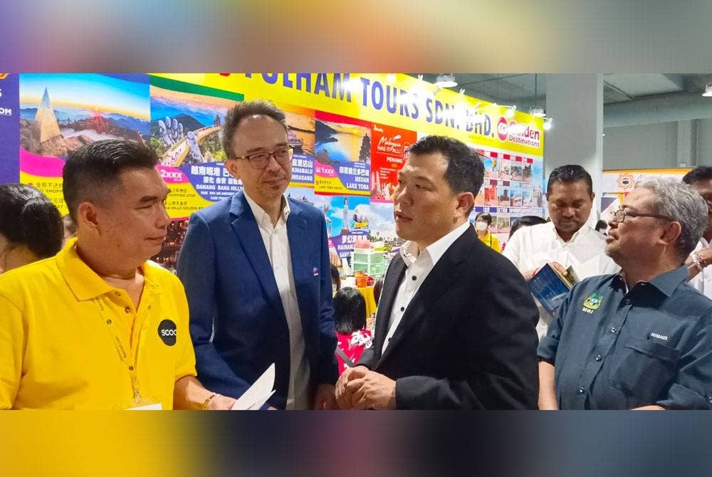 Yu Ken (tengah) menemani Sze Yee (dua dari kanan) melawat reruai yang disediakan dalam pameran MATTA Fair Perak 2023 di Ipoh.