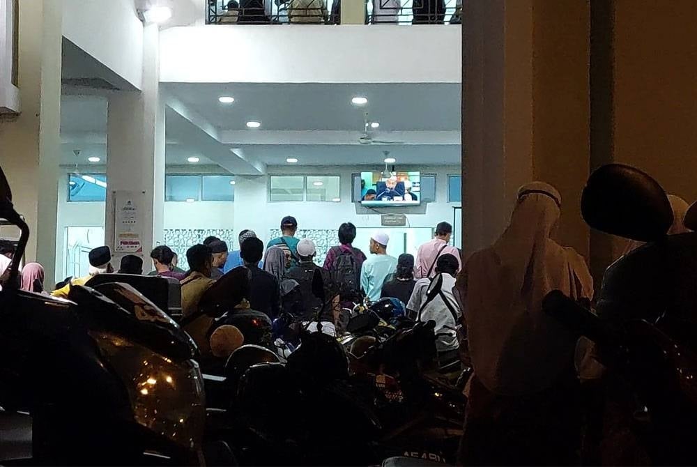 Orang ramai yang berada di luar masjid melihat kuliah maghrib UAI melalui skrin.