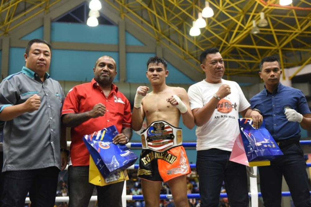 Nik Mahmud (dua dari kanan) dan Mazlisham (tengah) yang mengungguli Tali Pinggang Sinar Harian Kejohanan Kuda Merah Muay Thai Antarabangsa di Stadium Titiwangsa, Kuala Lumpur pada Sabtu. - Foto Rafeq Redzuan