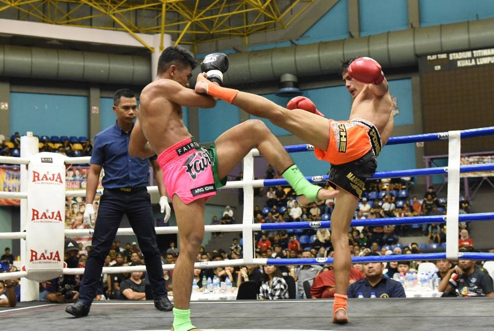 Mazlisham (kanan) melakukan asakan ke atas Ariq dalam Kejohanan Kuda Merah Muay Thai Antarabangsa di Stadium Titiwangsa, Kuala Lumpur pada Sabtu. - Foto Rafeq Redzuan